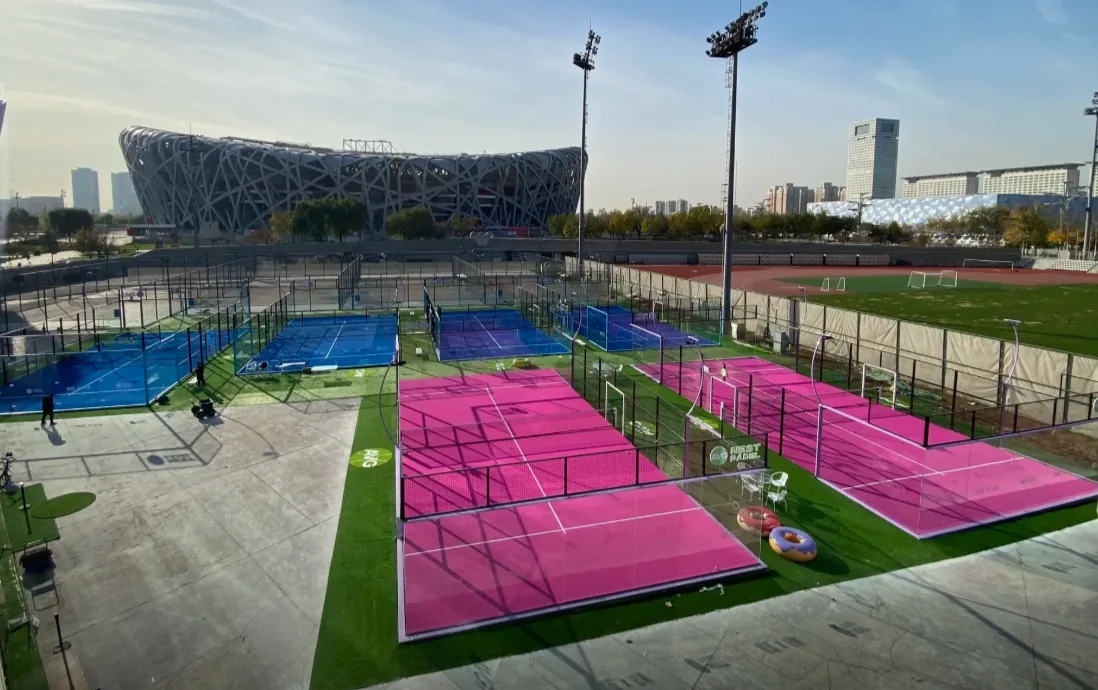 Colorful padel court complex beside a major stadium